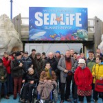groepsfoto voor de ingang van SeaLife in Blankenberge. Deze uitstap voor cliënten werd gedaan in kader van Time4Society.