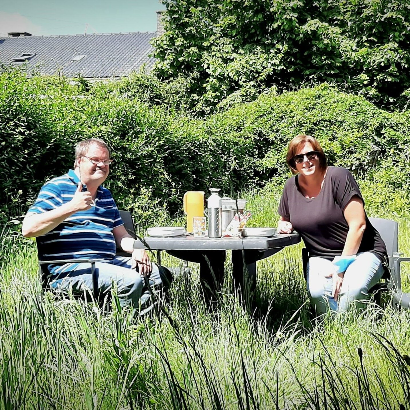 Afbeelding die de module inclusief wonen in beeld brengt. Begeleidster zit samen met cliënt buiten aan tafel te eten.